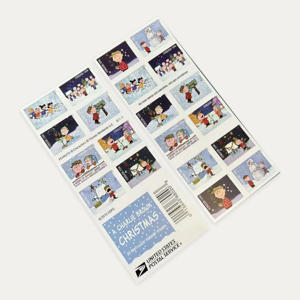 Photograph of a A Charlie Brown Christmas Forever stamp booklet showing both sides and the booklet cover