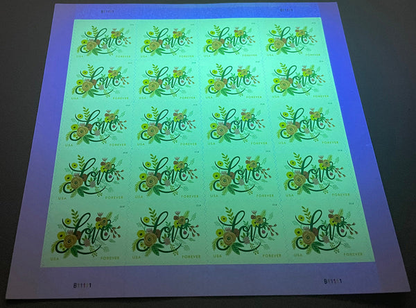 Love Flourishes stamp sheet under ultraviolet authentication light